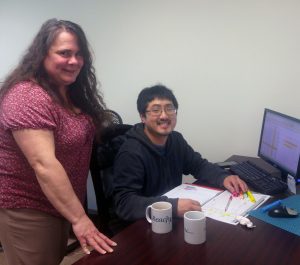 Woman and young man at computer desk