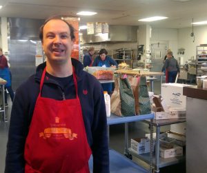 man wearing apron at food kitchen