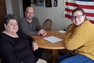 Three people at table smiling