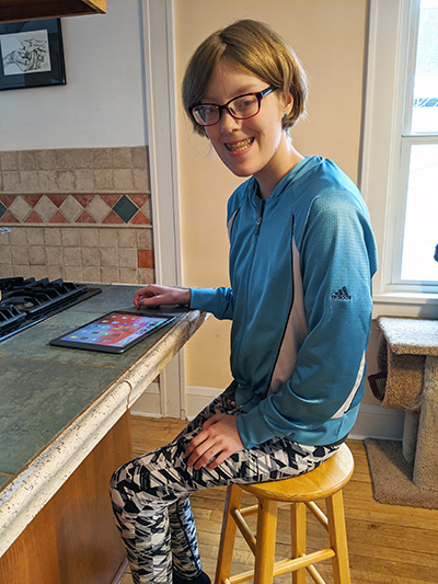 Young woman sitting at counter with iPad