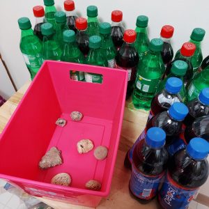 Pop rocks with rocks in bin and soda around it.