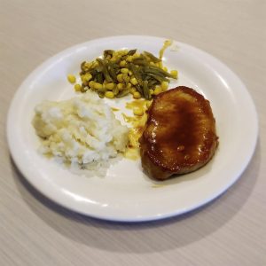 Calli's pork chop meal with mash potatoes and veggies.